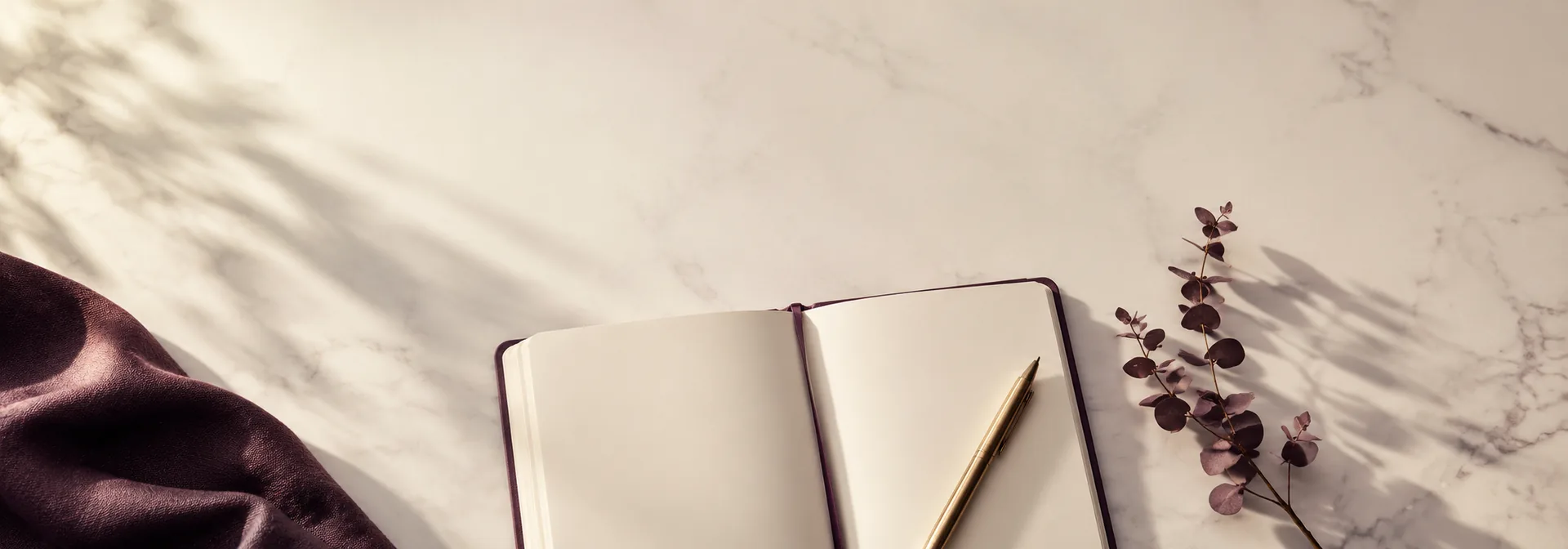 An open notebook and pen on a marble surface
